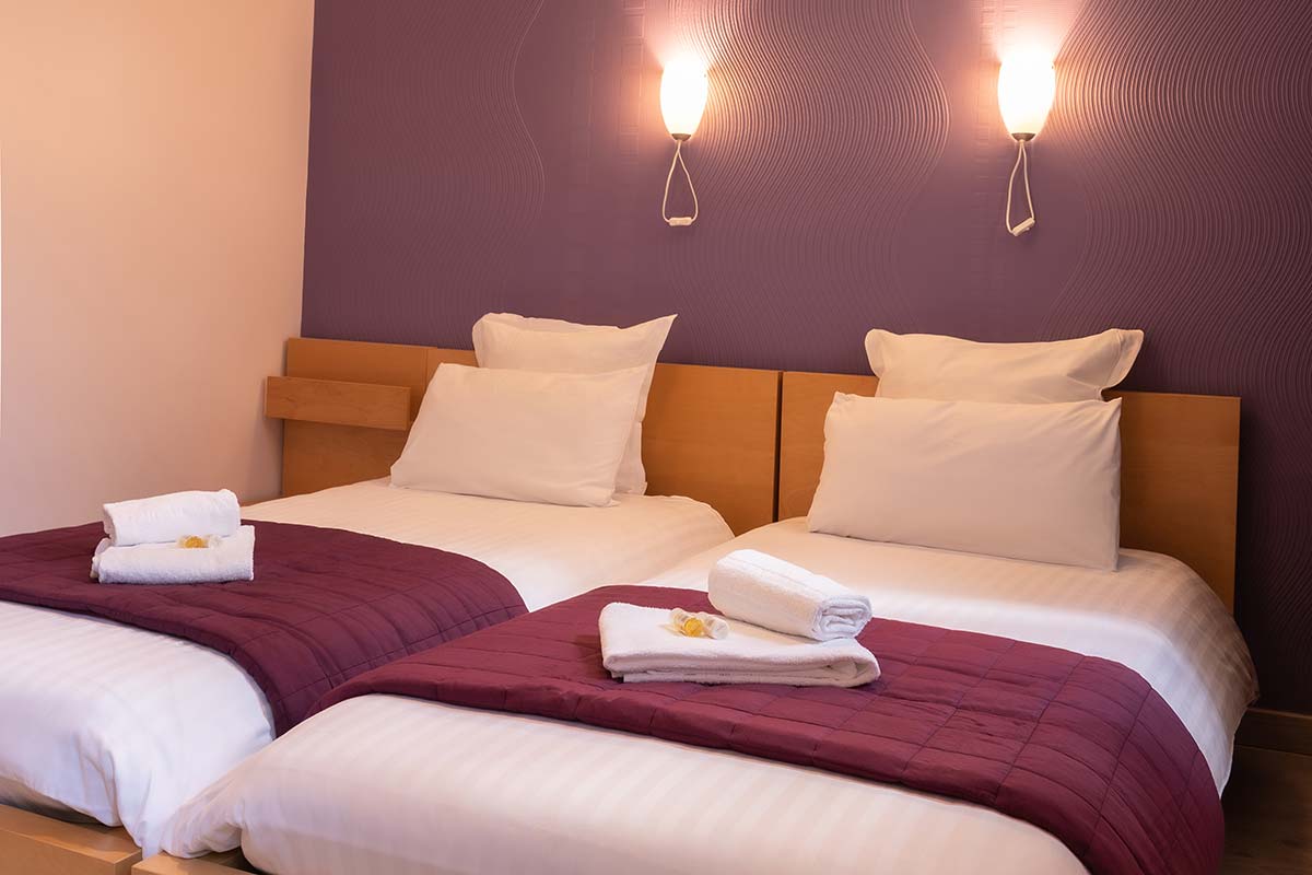 Deux lits simple dans une des chambres de l'hôtel près de Saintes
